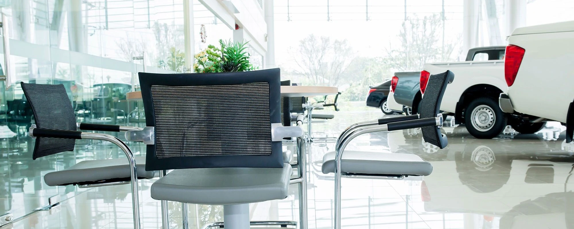 Modern car showroom interior with sleek black chairs and small tables Modern car showroom interior with sleek black chairs and small tables